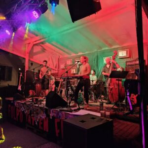 Groupe de musique CVQ sur scène, illuminé de lumières colorées
